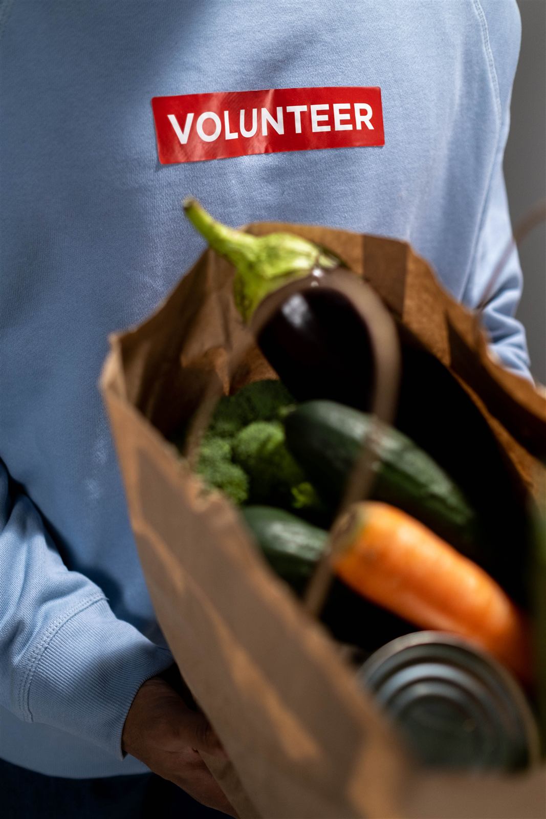 Volunteer packing a grocery bag with donated food